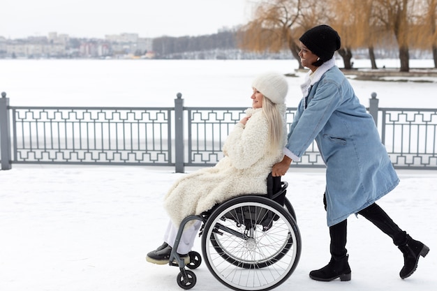 Donna del colpo pieno che aiuta un amico disabile