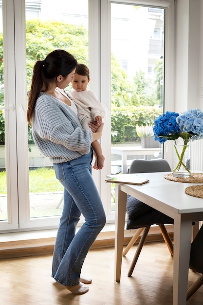 Free photo full shot woman holding baby