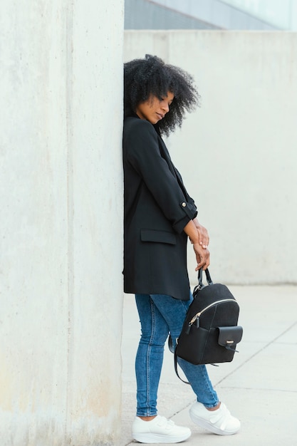 Free photo full shot woman holding backpack