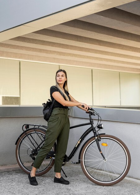 自転車を保持しているフルショットの女性