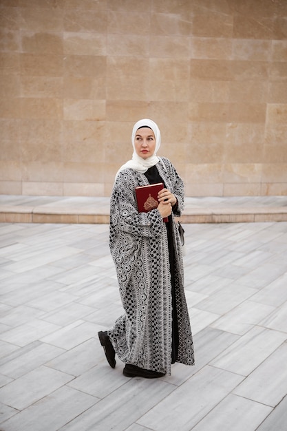 Free photo full shot woman holding book