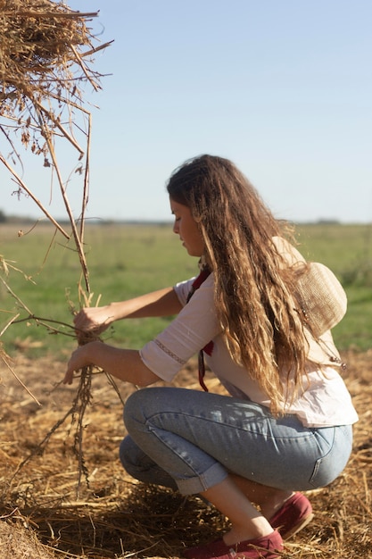 Foto gratuita donna a tutto campo che tiene i rami