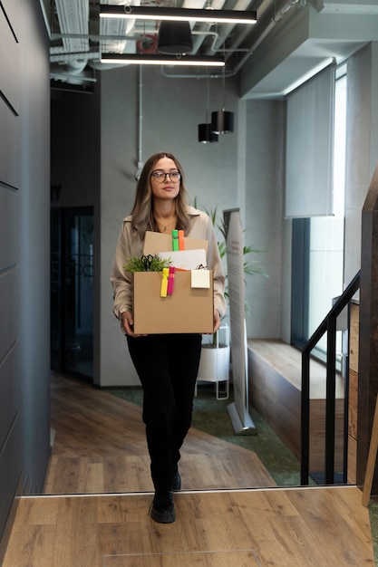 Free photo full shot woman holding cardboard box