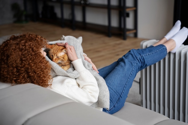 Foto gratuita gatto della holding della donna del colpo pieno in coperta
