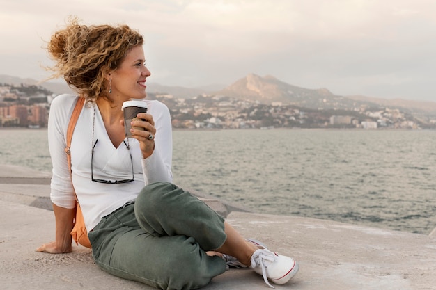 Free photo full shot woman holding coffee cup