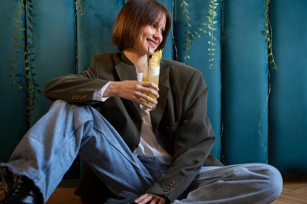 Full shot woman holding delicious cocktail