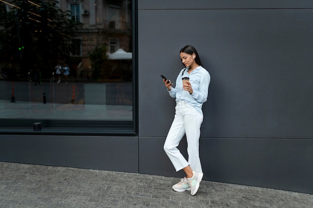 Full shot woman holding device