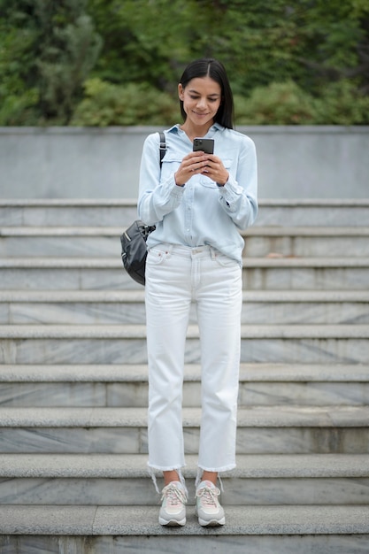 Full shot woman holding device