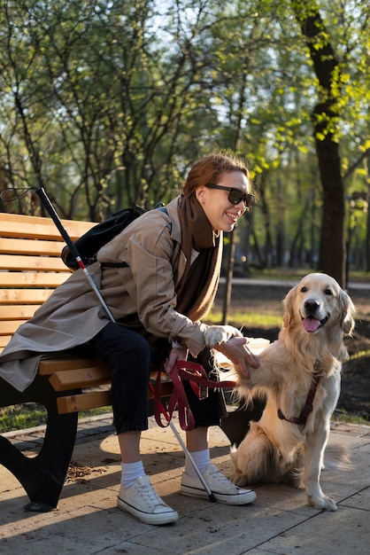 犬の足を保持しているフルショットの女性