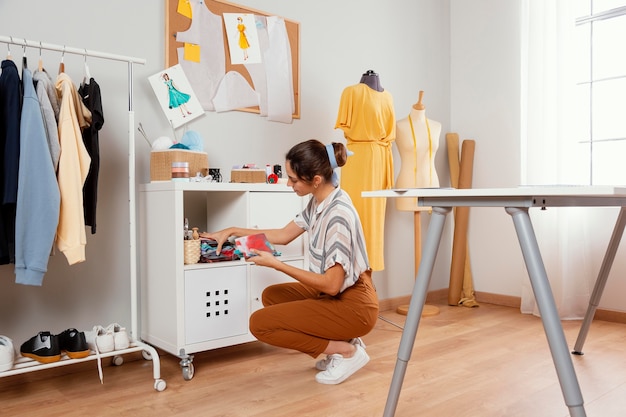 Full shot woman holding fabrics