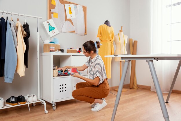 Full shot woman holding fabrics