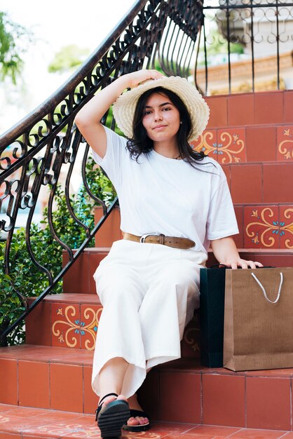 Full shot woman holding her hat