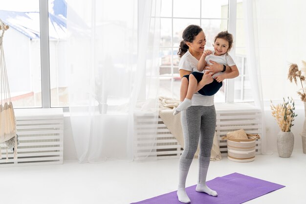 Full shot woman holding kid in her arms