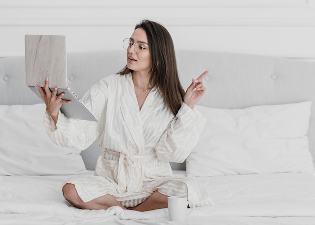 Free photo full shot woman holding laptop