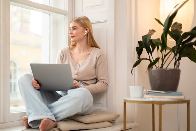 Full shot woman holding laptop