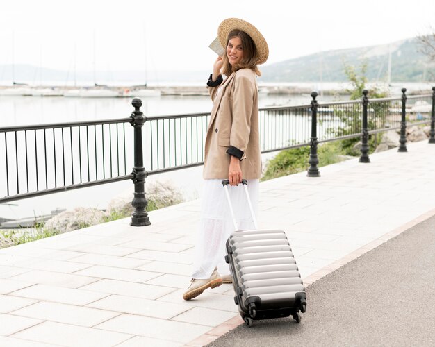 Full shot woman holding luggage