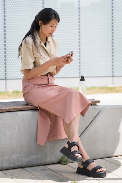 Full shot woman holding phone