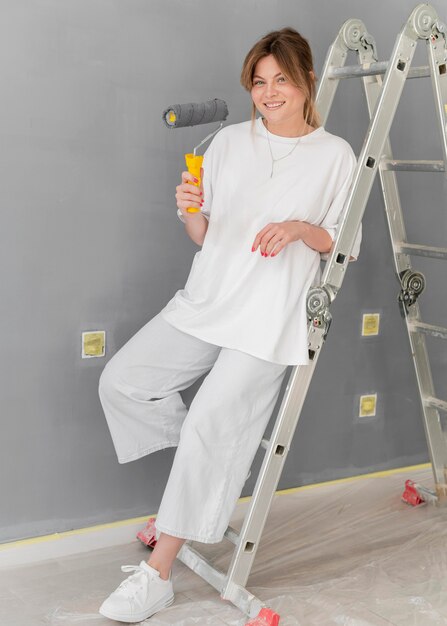 Full shot woman holding roller