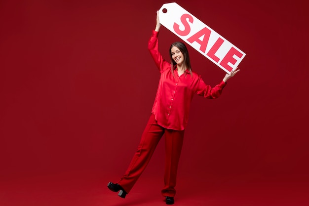 Free photo full shot woman holding sale sign