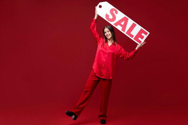 Full shot woman holding sale sign