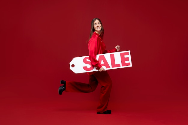 Free photo full shot woman holding sale tag