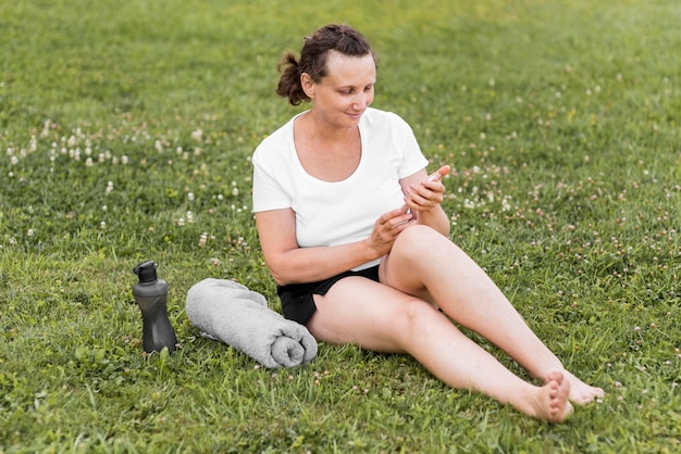 Full shot woman holding smartphone