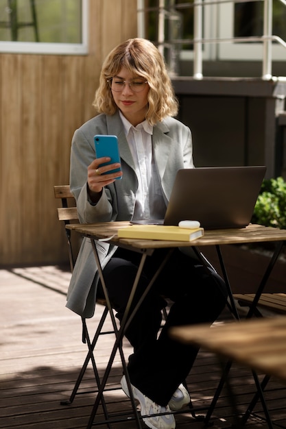 Full shot woman holding smartphone