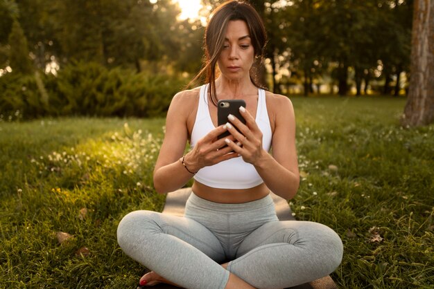 Free photo full shot woman holding smartphone