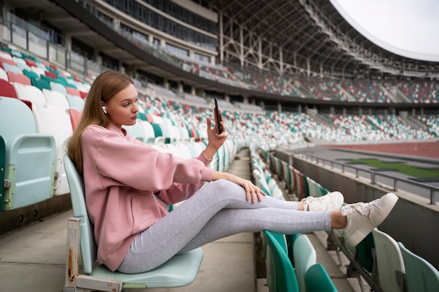 Foto gratuita smartphone della tenuta della donna della foto a figura intera