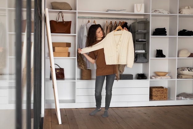 Full shot woman holding sweater