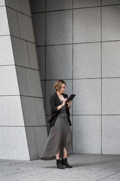 Full shot woman holding tablet