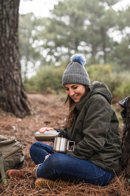 Full shot woman holding thermos