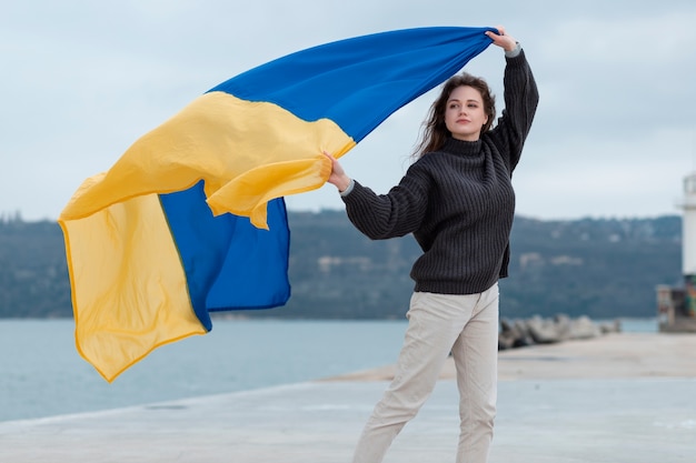 Full shot woman holding ukrainian flag