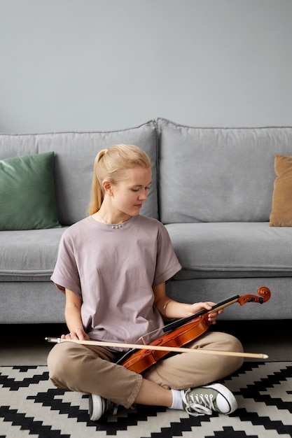 Full shot woman holding violin