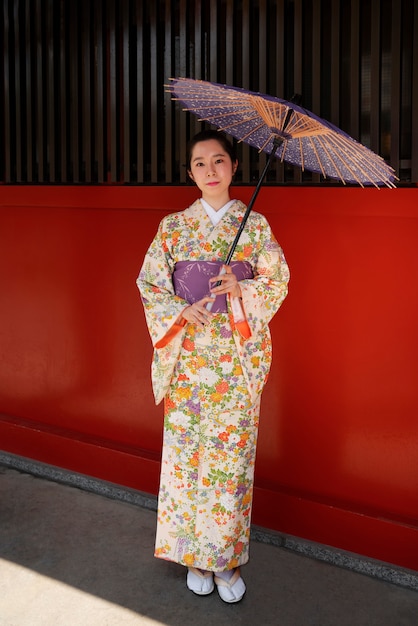 Full shot woman holding wagasa umbrella