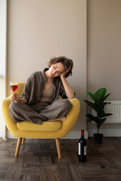 Free photo full shot woman holding wine glass