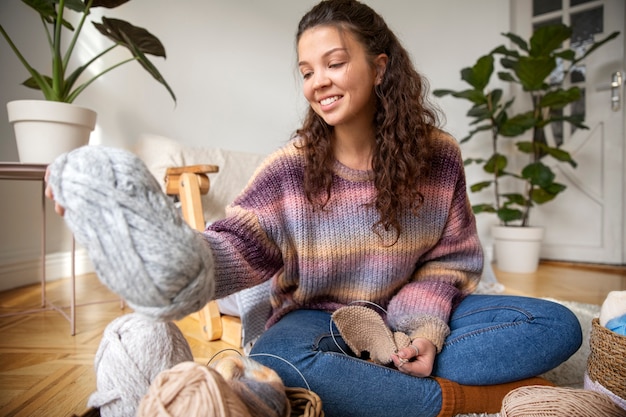 Full shot woman holding yarn