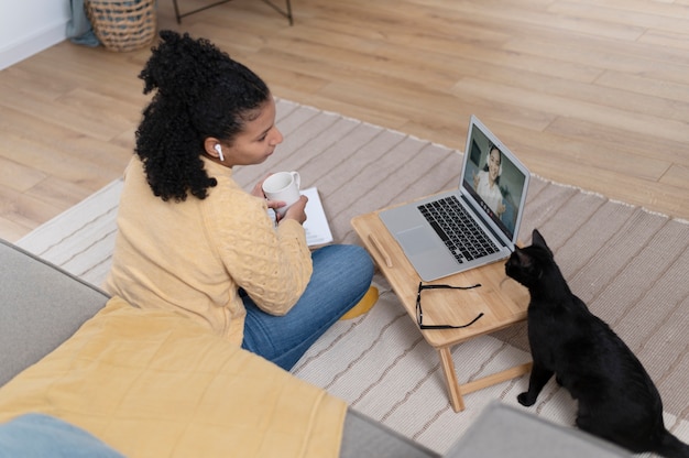 Foto gratuita donna a tutto campo a casa con il gatto