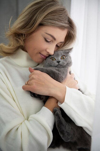 Full shot woman hugging cute cat