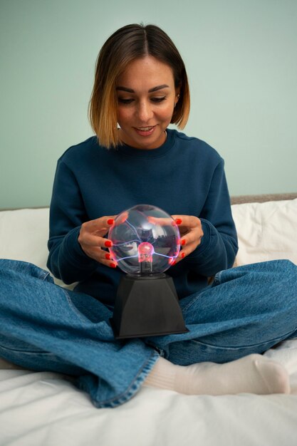 Free photo full shot woman interacting with a plasma ball