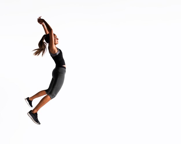 Full shot woman jumping indoors