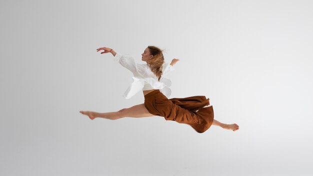 Full shot woman jumping in studio