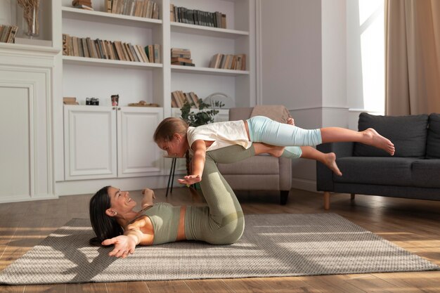 Full shot woman and kid doing yoga