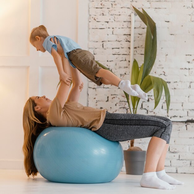 Full shot woman and kid exercising together