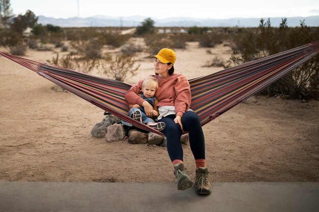 Free photo full shot woman and kid on hammock