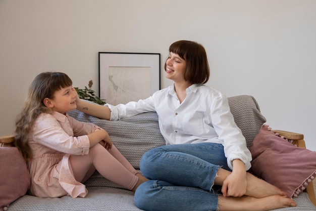 Full shot woman and kid in living room