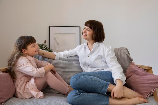 Full shot woman and kid in living room