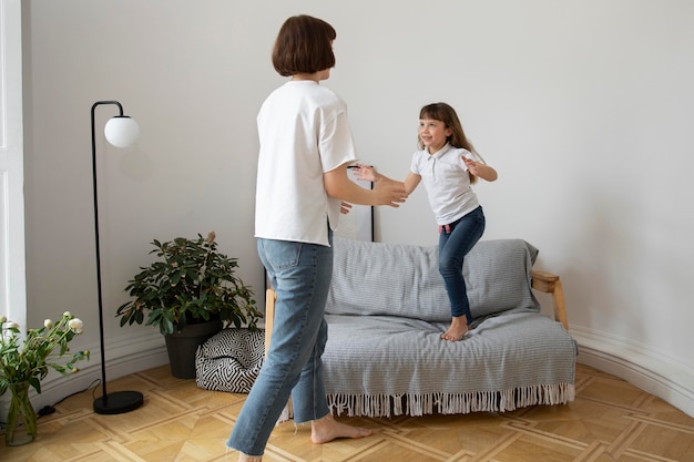 Free photo full shot woman and kid in living room