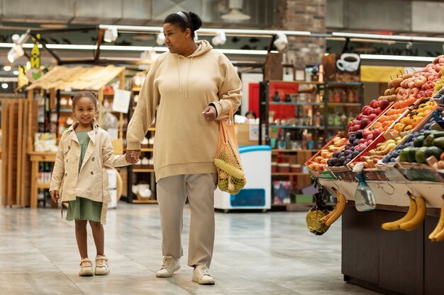 Full shot woman and kid at store