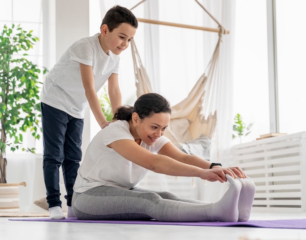 Full shot woman and kid working out